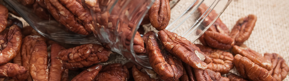 Pecans Falling Out of a Glass Jar on a Table