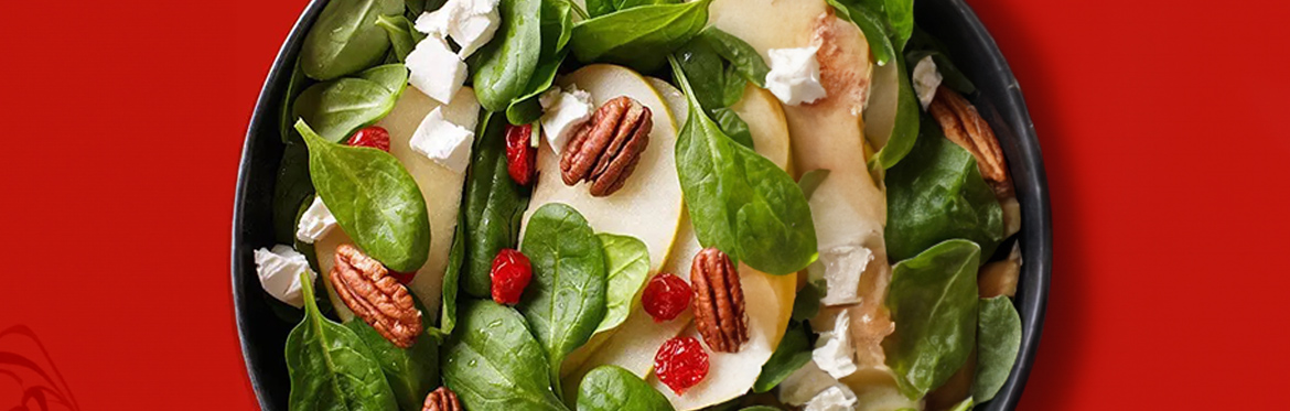 Apple Pecan Feta Salad Against Red Background