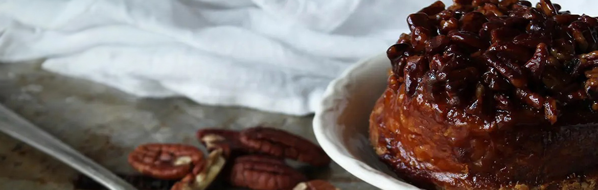 Pecan and Cherry Topped Christmas Pudding in White Bowl